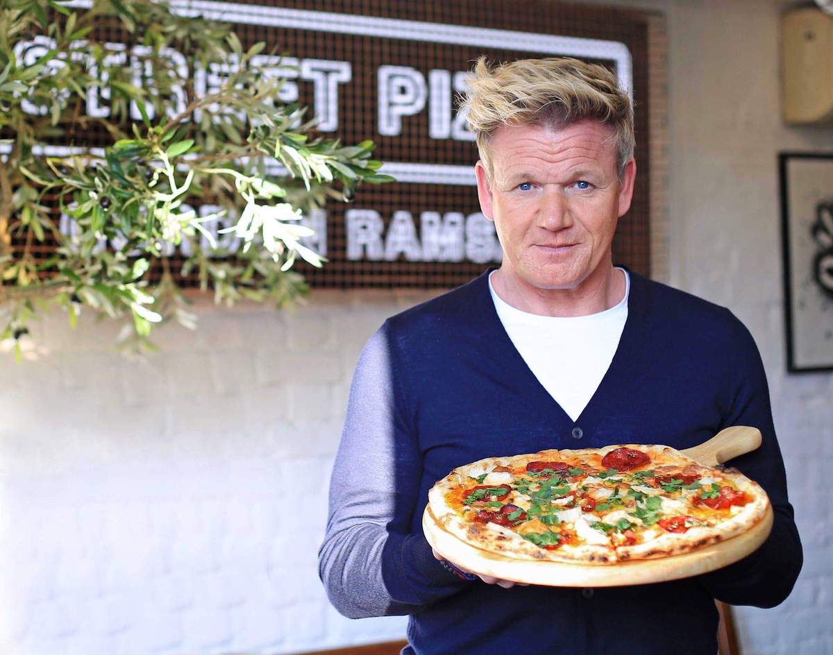 Image of a pizza holded by Gordon Ramsay